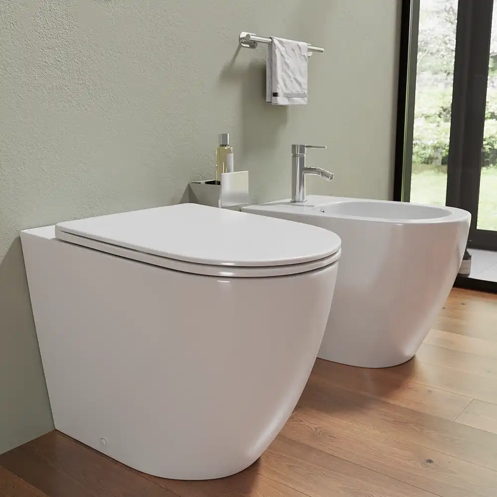 Sanitari filomuro in ceramica wc+bidet rimless mod. Europa bianco lucido - Vista laterale Sanitari filomuro in ceramica wc+bidet rimless mod. Europa bianco lucido - Vista laterale